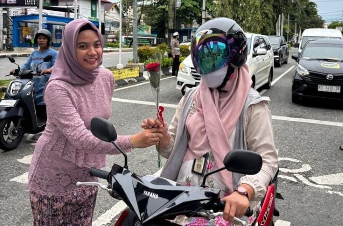 Personel Polresta Balikpapan menggelar aksi simpatik memperingati Hari Kartini dengan membagikan bunga kepada para pengendara yang berhenti di lampu merah. Foto: HO/Humas Polresta Balikpapan