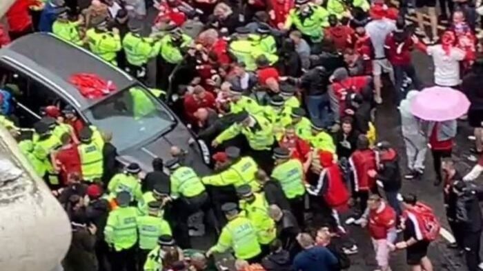 Polisi mengamankan mobil abu-abu dari amukan massa. Foto: telegraph.co.uk