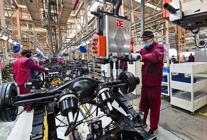 Karyawan bekerja di jalur perakitan truk di sebuah pabrik manufaktur kendaraan Jianghuai Automobile Group Corp. (JAC), di Qingzhou, provinsi Shandong, Tiongkok Timur. ( Foto: STR/AFP)