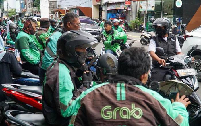 Pengemudi ojek daring Grab dan Gojek menunggu penumpang di Dukuh Atas, Jakarta, 3 Desember 2024. Foto : Ilham Balindra