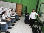 Seorang guru sedang menyampaikan materi menggunakan smart board kepada para siswa dan siswi di kelas. Foto: ANTARA/Auliya Rahman