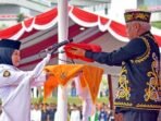 Basuki Hadimuljono selaku inspektur upacara menyerahkan bendera Merah Putih kepada pembawa baki, Aulia Novita, siswi SMAN 2 Penajam Paser Utara, Kalimantan Timur. Foto: HO/Humas Otorita IKN