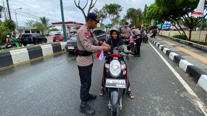 Brimob Polda Kaltim menggelar aksi inspiratif dengan membagikan 3.000 bendera Merah Putih kepada masyarakat Kaltim. Foto: HO/Humas Polda Kaltim