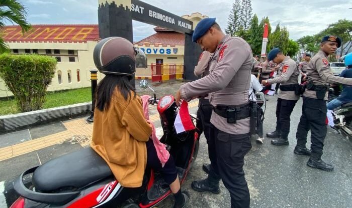 Brimob Polda Kaltim menggelar aksi inspiratif dengan membagikan 3.000 bendera Merah Putih kepada masyarakat Kaltim. Foto: HO/Humas Polda Kaltim