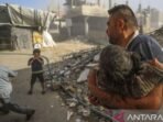 Arsip foto - Seorang laki-laki menggendong anak yang terluka untuk mendapat bantuan setelah serangan udara militer Israel di kamp pengungsi Jabalia, Jalur Gaza, Palestina (21/5/2025). Foto: ANTARA/Xinhua/Mahmoud Zaki/aa