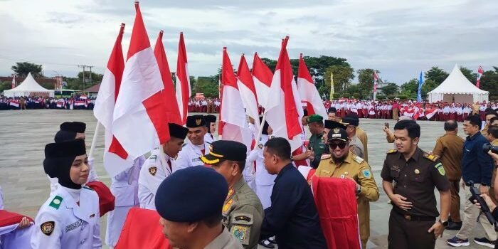 Pembagian bendera secara simbolis dipimpin Wakil Bupati Paser, Ikhwan Antasari, kepada pelajar, mahasiswa, perwakilan kecamatan, dan masyarakat di Halaman Kantor Bupati Paser, pada Selasa (12/8/2025). Foto: BorneoFlash/IST