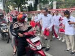 Wakil Gubernur Kaltim, Seno Aji saat membagikan bendera merah putih pada kendaraan yang lewat di kawasan Taman Samarendah, Jalan Bhayangkara, pada Sabtu (16/8/2025). Foto: BorneoFlash/Nur Ainunnisa