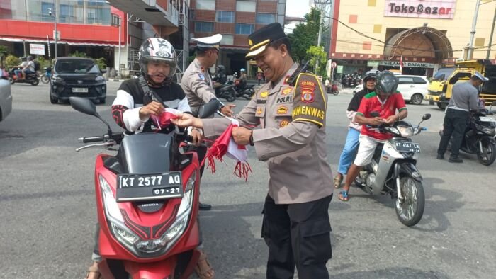Kapolresta Balikpapan Kombes Pol Anton Firmanto, SH, SIK, MSi, memimpin langsung aksi pembagian 2.000 lembar Bendera Merah Putih kepada pengendara yang melintas di kawasan Simpang Traffic Light Plaza – Jembatan Emas, Balikpapan Kota. Foto: HO/Humas Polresta Balikpapan
