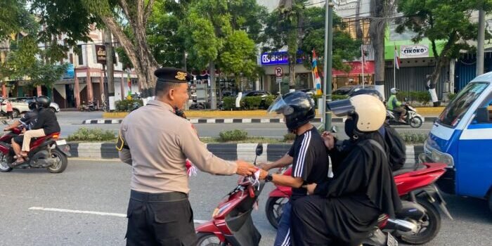 Suasana semarak jelang peringatan Hari Ulang Tahun ke-80 Kemerdekaan Republik Indonesia, jajaran Polresta Balikpapan turun langsung ke jalan membagikan ratusan Bendera Merah Putih kepada para pengendara. Foto: BorneoFlash/Agung Putra