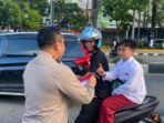 Suasana semarak jelang peringatan Hari Ulang Tahun ke-80 Kemerdekaan Republik Indonesia, jajaran Polresta Balikpapan turun langsung ke jalan membagikan ratusan Bendera Merah Putih kepada para pengendara. Foto: BorneoFlash/Agung Putra