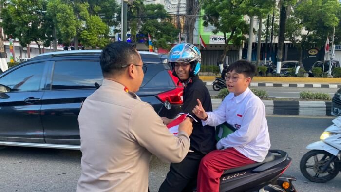Suasana semarak jelang peringatan Hari Ulang Tahun ke-80 Kemerdekaan Republik Indonesia, jajaran Polresta Balikpapan turun langsung ke jalan membagikan ratusan Bendera Merah Putih kepada para pengendara. Foto: BorneoFlash/Agung Putra