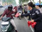 Puluhan Polisi Wanita (Polwan) Polda Kaltim turun langsung ke jalan membagikan ratusan bendera Merah Putih kepada para pengendara, mulai dari sepeda motor, mobil pribadi, hingga truk besar yang melintas di depan Mapolda Kaltim. Foto: HO/Humas Polda Kaltim