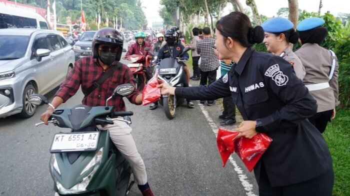 Puluhan Polisi Wanita (Polwan) Polda Kaltim turun langsung ke jalan membagikan ratusan bendera Merah Putih kepada para pengendara, mulai dari sepeda motor, mobil pribadi, hingga truk besar yang melintas di depan Mapolda Kaltim. Foto: HO/Humas Polda Kaltim