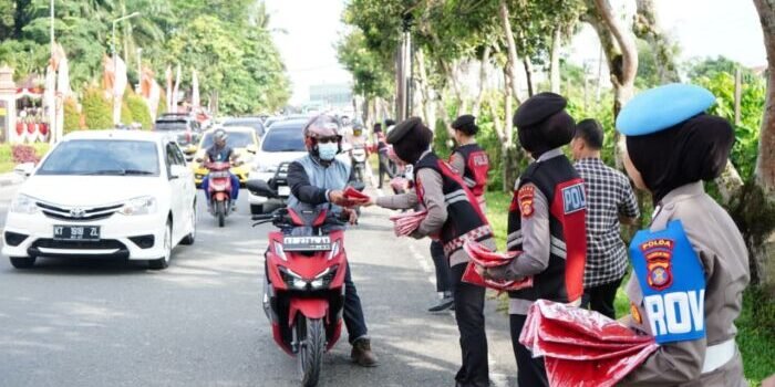 Puluhan Polisi Wanita (Polwan) Polda Kaltim turun langsung ke jalan membagikan ratusan bendera Merah Putih kepada para pengendara, mulai dari sepeda motor, mobil pribadi, hingga truk besar yang melintas di depan Mapolda Kaltim. Foto: HO/Humas Polda Kaltim