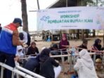 Puluhan pelajar dan pegiat lingkungan justru sibuk merangkai bambu dan batok kelapa, serta memanfaatkan tangga lipat bekas untuk membuat “rumah” bagi ikan-ikan di laut di Pantai Jalasena, Lamaru, Balikpapan Timur, pada Selasa (12/8/2025). Foto: HO/Pertamina Patra Niaga