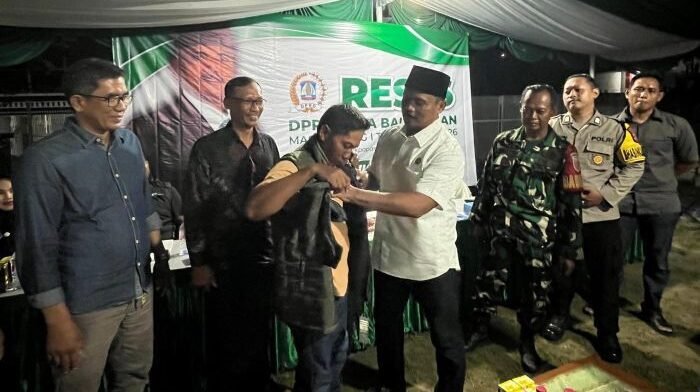 Anggota DPRD Kota Balikpapan, Halili Adinegara saat menyerahkan jaket secara simbolis kepada warga, usai Kegiatan Reses masa sidang III tahun 2025 di lingkungan RT 28 Kelurahan Gunung Samarinda, Kecamatan Balikpapan Utara, pada Minggu Malam (19/10/2025). Foto: BorneoFlash/Ardian