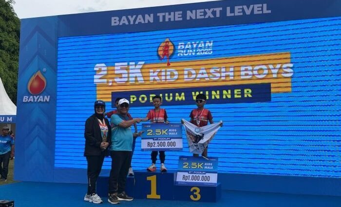 Wakil Wali Kota Balikpapan, Bagus Susetyo, didampingi istri Siti Kotijah Saat Menyerahkan Hadiah Kepada Pemenang Kategori 2,5K Kids Dash Boys Bayan Run di Lapangan Merdeka Balikpapan, pada Minggu (12/10/2025). Foto: BorneoFlash/Niken Sulastri