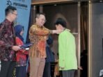 Direktur Utama PHI Sunaryanto menyerahkan secara simbolis beasiswa program Beasiswa Sobat Bumi Kalimantan (BSBK) pada sebuah acara inaugurasi yang berlangsung di Balikpapan, Kalimantan Timur, pada Senin (17/11/2025). Foto: HO/PHI
