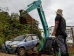 Operator alat berat mengevakuasi satu unit kendaraan roda empat yang tertimbun material longsor di UIN Imam Bonjol Padang, pada Selasa (25/11/2025). Foto: ANTARA/Muhammad Zulfikar