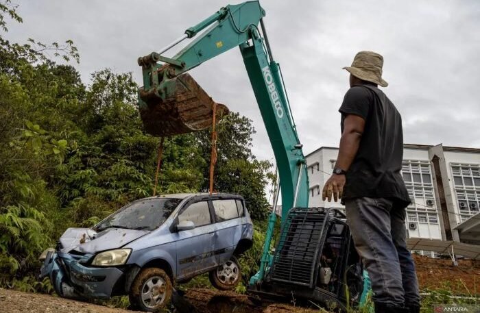 Operator alat berat mengevakuasi satu unit kendaraan roda empat yang tertimbun material longsor di UIN Imam Bonjol Padang, pada Selasa (25/11/2025). Foto: ANTARA/Muhammad Zulfikar