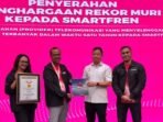 penghargaan rekor MURI untuk SMARTFREN (ki-ka) Wakil Direktur Utama MURI, Osmar Susilo (kedua kanan) menyerahkan penghargaan rekor MURI untuk SMARTFREN kepada Chief Marketing Officer SMARTFREN XLSMART, Sukaca Purwokardjono (kedua kiri), di damping oleh Division Head Brand Communication Edtine Pamilien Gensana (kiri) dan Group Head Corporate Communication & Sustainability XLSMART, Reza Mirza di Jakarta, pada Senin (3/11/2025). Foto: HO/ XLSMART