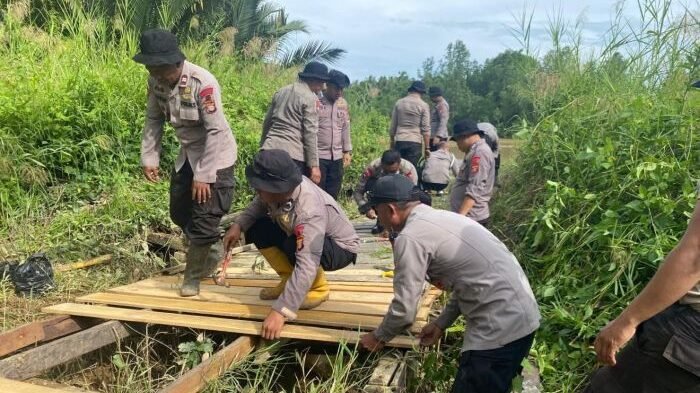 Personel Kompi 2 Batalyon C Pelopor melaksanakan perbaikan jembatan utama yang menghubungkan Desa Suliliran dengan Desa Pulau Rantau, Kecamatan Paser Belengkong, pada Jumat (12/11/2025). Foto: HO/Brimob Polda Kaltim