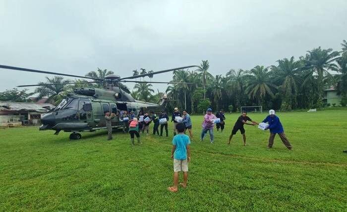 TNI bersama masyarakat memindahkan bantuan kepada korban terdampak bencana yang diangkut menggunakan helikopter di Sumatera Barat. FOTO : Antara/HO-Humas Lanud Sutan Sjahrir.