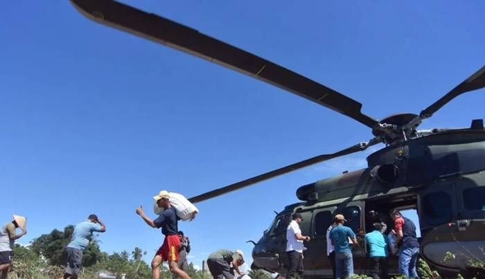 Warga memindahkan bantuan yang didistribusikan dari Helikopter Caracal TNI-AU Skadron Udara 8 Lanud Atang Sendjaja di daerah terisolir akibat bencana di Nagari Tiku V Jorong, Agam, Sumatera Barat, Senin (1/12/2025). FOTO : ANTARA FOTO/Iggoy el Fitra/YU
