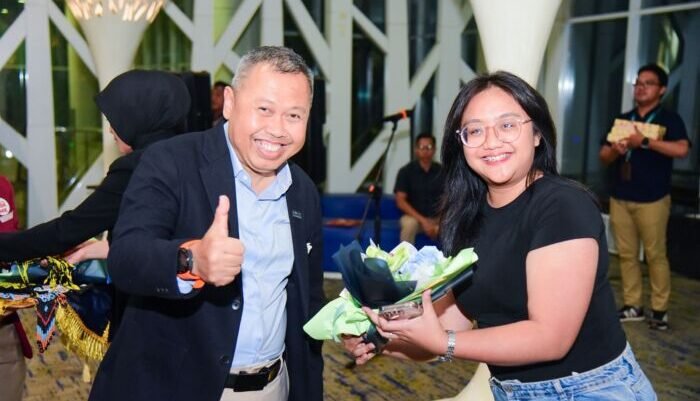 Jajaran pejabat PT Angkasa Pura Indonesia, menyapa penumpang dan menyerahkan kenang-kenangan bunga dan souvenir khas Kalimantan kepada para penumpang terakhir di tahun 2025, pada Rabu (31/12/2025). Foto: BorneoFlash/Ist