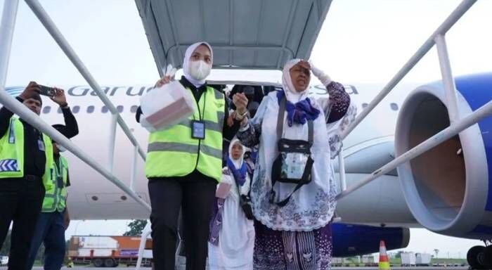 Seorang hajjah lanjut usia Kloter 20 Debarkasi Medan dipapah oleh petugas menuju bus Damri saat turun dari tangga pesawat Garuda Indonesia di Bandara Kualanamu Deli Serdang, Sumatera Utara, Sabtu (5/7/2025). FOTO : ANTARA/HO-PPIH Debarkasi Medan.