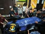 Tim Dokpol membungkus dengan terpal peti jenazah Deden Maulana korban kecelakaan pesawat ATR 42-500 setelah teridentifikasi oleh tim DVI Biddokkes Polda Sulsel untuk diserahkan kepada perwakilan keluarga selanjutnya akan diterbangkan ke Jakarta, di Posko DVI Biddokkes Polda Sulsel, Jalan Kumala Makassar, Sulawesi Selatan, Rabu (21/1/2026) malam. Foto: BorneoFlash/ANTARA/Darwin Fatir