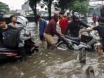 Warga membantu pengendara sepeda motor yang mogok saat menerobos banjir di Jalan Daan Mogot, Jakarta, Kamis (22/1/2026). Banjir setinggi 50-60 cm akibat hujan berintensitas tinggi serta buruknya sistem drainase tersebut membuat sejumlah kendaraan mogok dan lalu lintas terganggu. Foto: BorneoFlash/Antara Foto/Ika Maryani