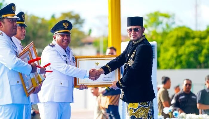Gubernur Kalimantan Timur, H. Rudy Mas'ud, saat menyerahkan penghargaan kepada Camat Balikpapan Barat, Erwin, pada peringatan HUT ke 69 Provinsi Kaltim, di Samarinda, pada Jumat (9/1/2026). Foto: HO/Humas Pemkot Balikpapan