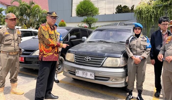Personel Satpol PP Kaltim Bidang Trantibum saat mengamankan kendaraan dinas yang masih dikuasai pensiunan ASN. Foto: BorneoFlash/Nur Ainunnisa