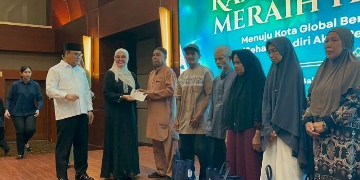 Staf Ahli TP- PKK Kota Balikpapan, Siti Kotijah didampingi Wakil Wali Kota Balikpapan, Bagus Susetyo saat menyerahkan paket sembako dan bantuan uang tunai kepada para lansia, di Blue Sky Hotel  Balikpapan, pada Selasa (3/3/2026). Foto: BorneoFlash/Niken Sulastri