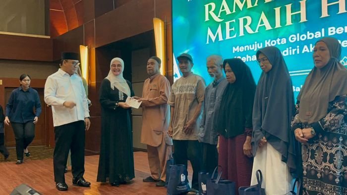 Staf Ahli TP- PKK Kota Balikpapan, Siti Kotijah didampingi Wakil Wali Kota Balikpapan, Bagus Susetyo saat menyerahkan paket sembako dan bantuan uang tunai kepada para lansia, di Blue Sky Hotel  Balikpapan, pada Selasa (3/3/2026). Foto: BorneoFlash/Niken Sulastri
